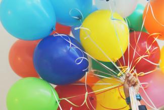 Hand holding a large bundle of balloons